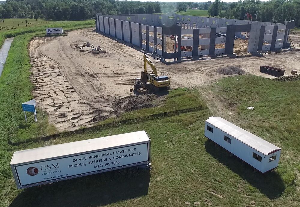 Construction site of a new industrial building with a CSM trailer in the foreground