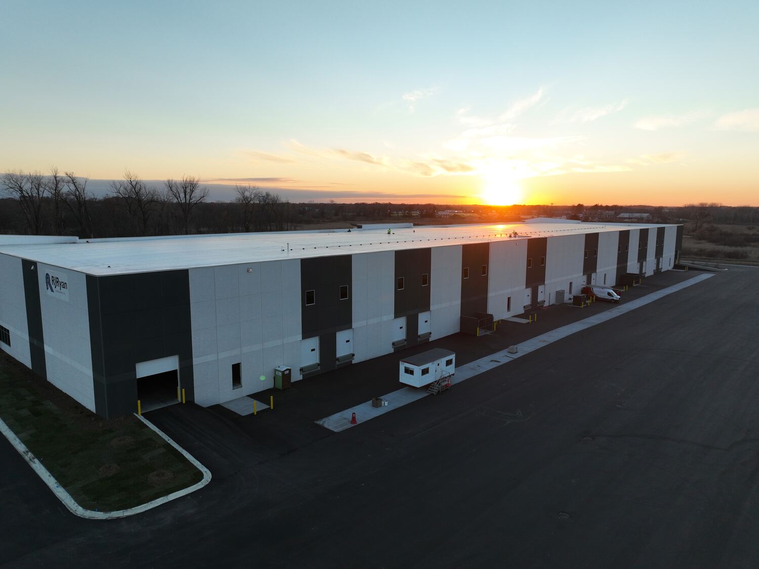 Industrial warehouse with loading docks at sunset