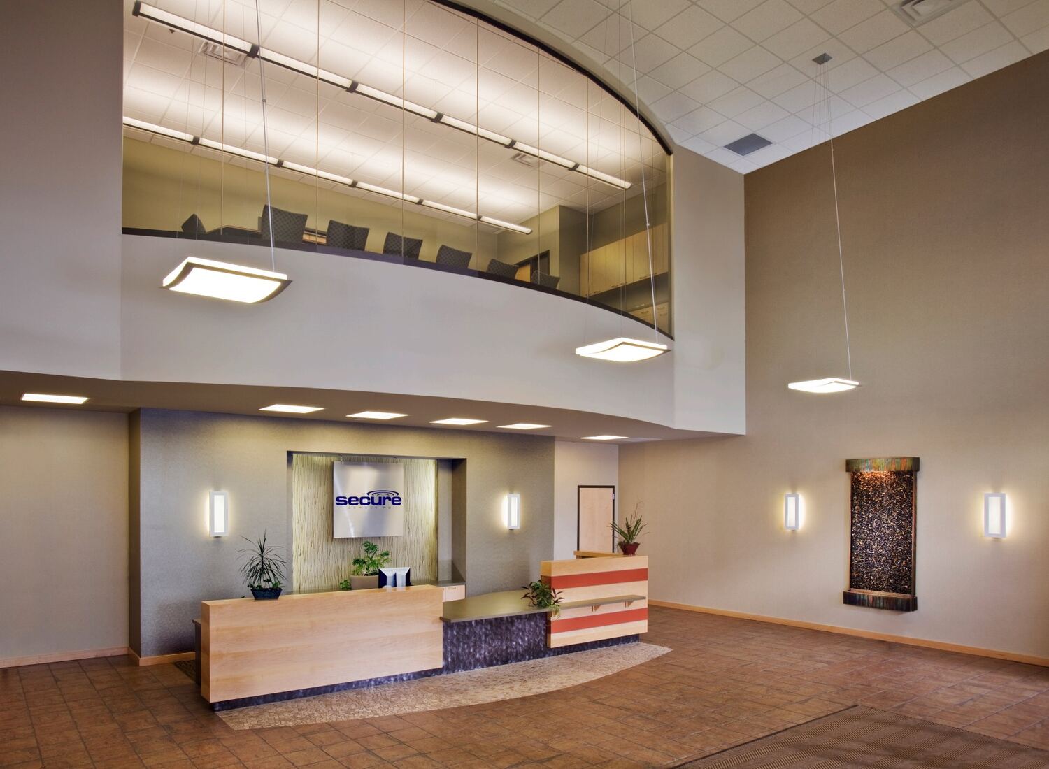 Office lobby with a reception desk and a curved two-story ceiling