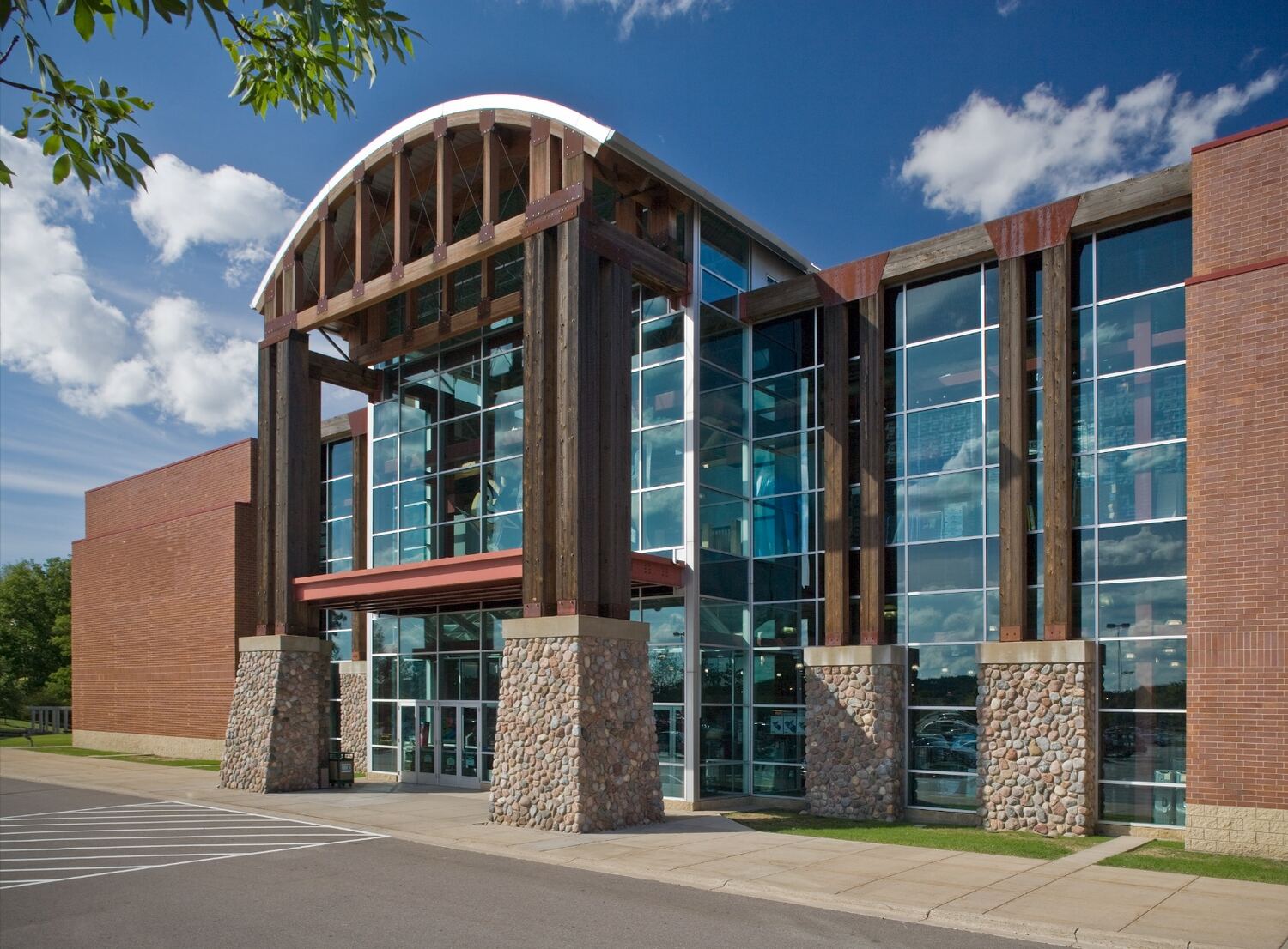 Retail building with a timber-framed glass entrance and stone piers