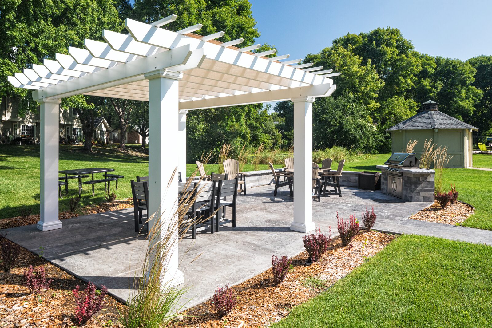 Pergola patio with outdoor seating and a grill at Birch Lake Townhomes