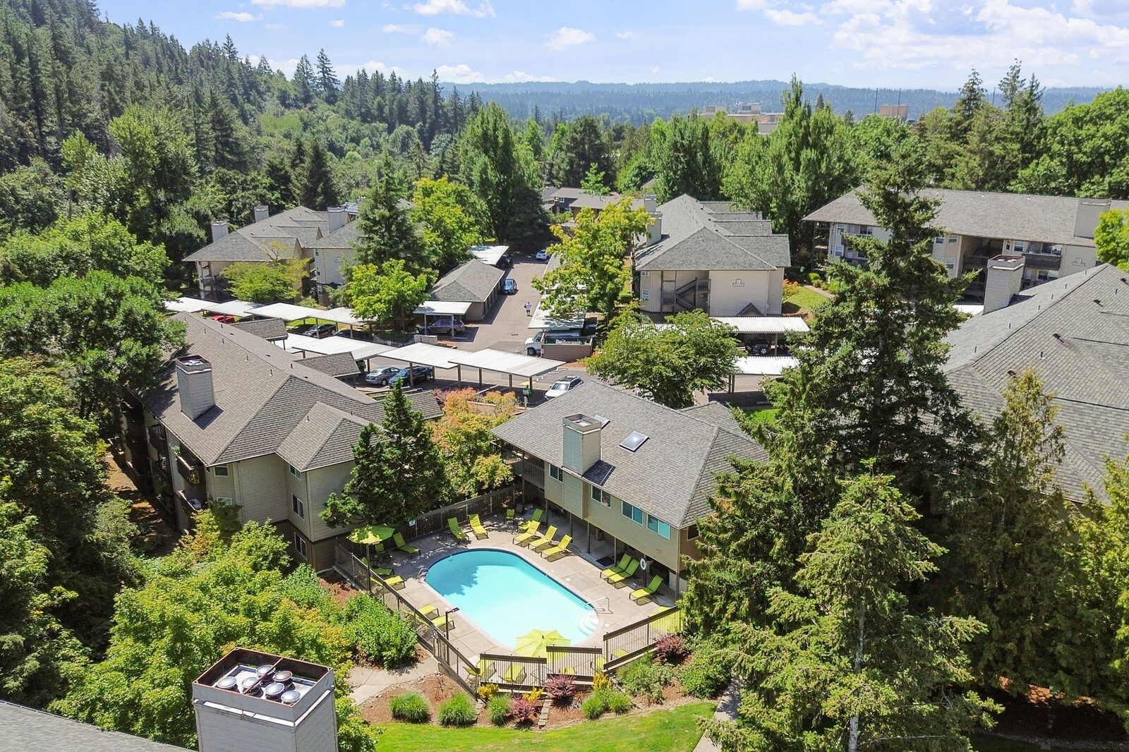 Aerial view of Creekside Apartments with the pool among the trees